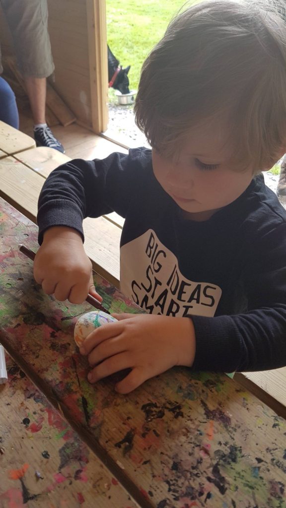 A small child painting rocks
